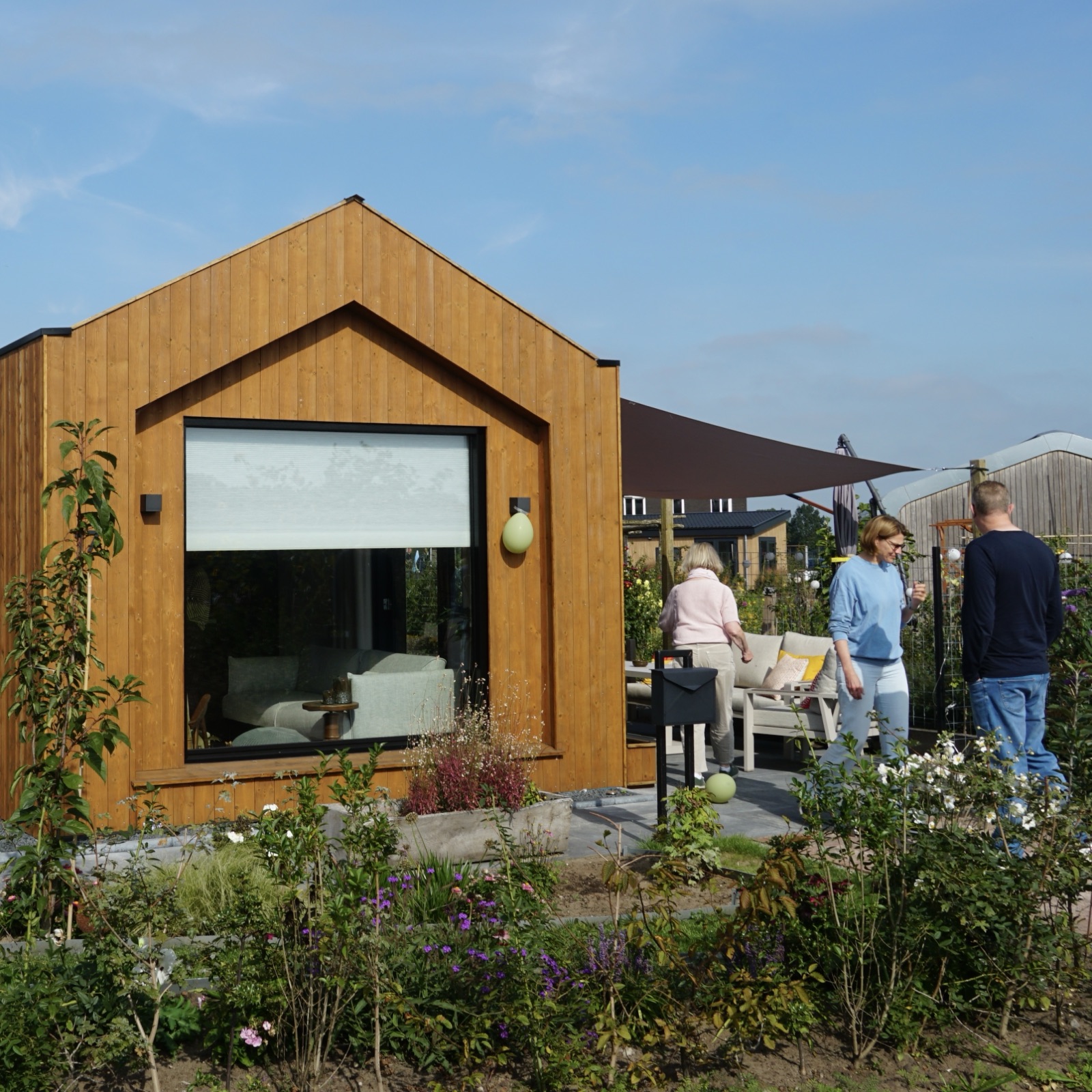 Bezoekers bij een tiny house met groot raam